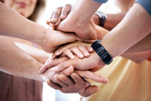 A closeup cropped shot of diverse hands stacked on top of each other